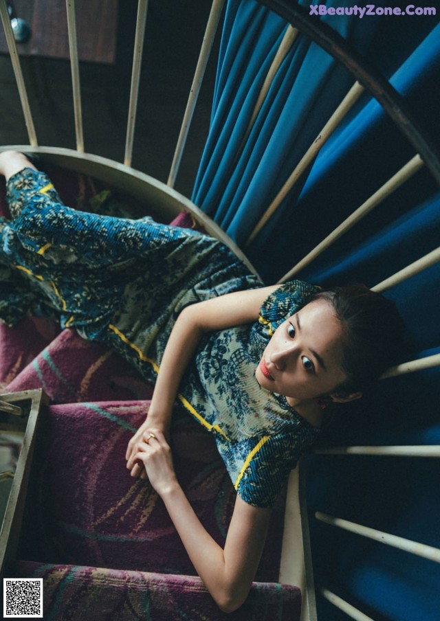 A woman laying on top of a spiral staircase.
