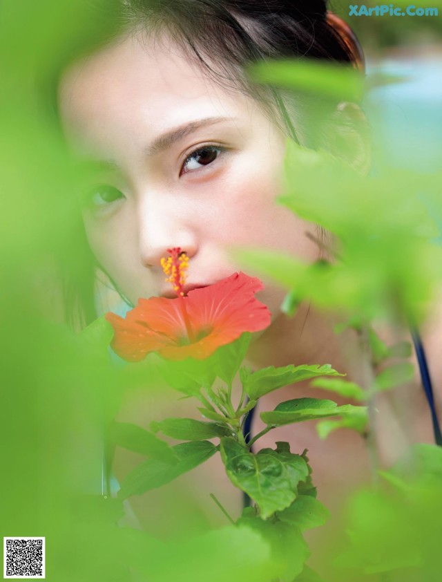 A woman with a flower in her mouth. 