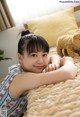 A young girl laying on a bed with a stuffed animal.