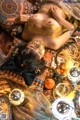 A woman laying on top of a bed covered in gold and orange items.